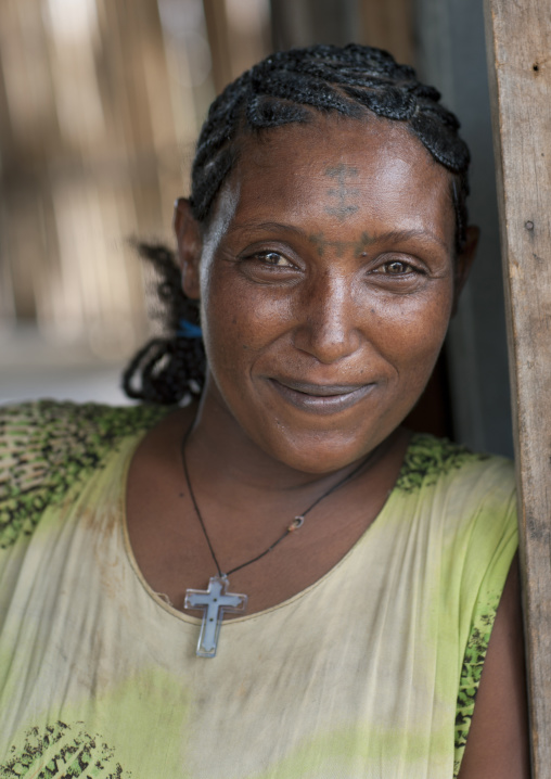 Tattooed forehead woman with a christian cross pendant Ethiopia