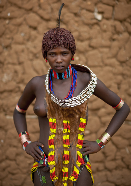 Hamer Beautiful Traditionally Dressed Hamer Tribe Woman Posing In Front Of Clay House Omo Valley Ethiopia