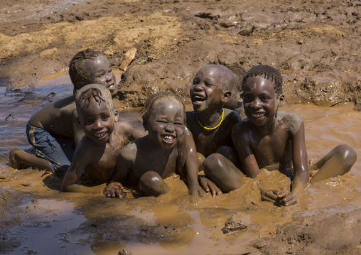 Nyangatom Kids Playing In Muddy Water, Kangate, Omo Valley, Ethiopia