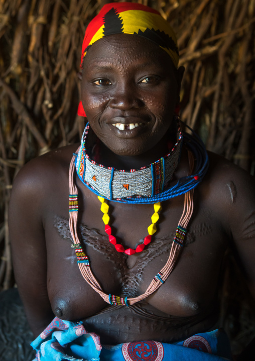 Smiling toposa tribe woman with scarified face, Omo valley, Kangate, Ethiopia