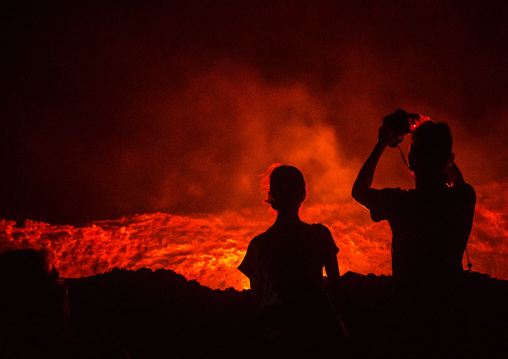 Tourists taking pictures in front of the living lava lake in the crater of erta ale volcano, Afar region, Erta ale, Ethiopia