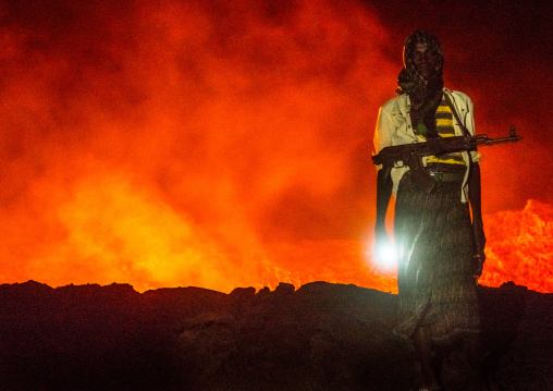 Afar guard in front of the living lava lake in the crater of erta ale volcano, Afar region, Erta ale, Ethiopia