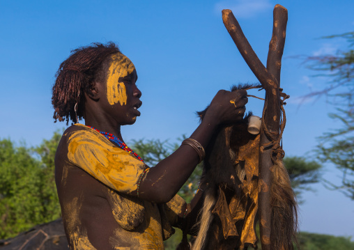 Dassanech tribe woman dressing for the dimi ceremony to celebrate the circumcision of the teenagers, Omo valley, Omorate, Ethiopia