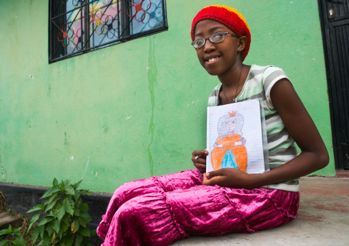 Rastafari girl called kizzy showing a princess she draws, Oromo, Shashamane, Ethiopia