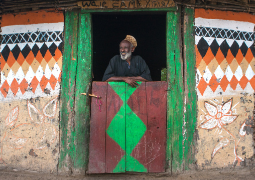 Ethiopia, Kembata, Alaba Kuito, ethiopian muslim man standing in front of his traditional painted house