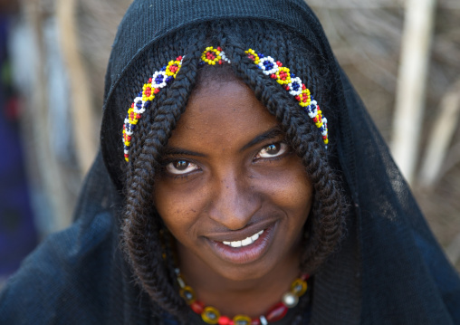 Portrait of a smiling Afar tribe girl with braided hair ands beaded headband, Afar region, Chifra, Ethiopia