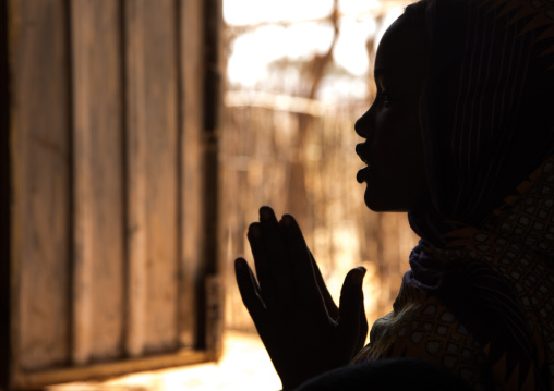 Silhouette of a Borana woman praying during sunday church service, Oromia, Yabelo, Ethiopia