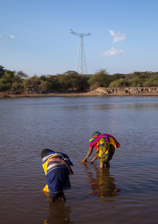 Borana tribe people filling jerricans in a water reservoir used for animals, Oromia, Yabelo, Ethiopia