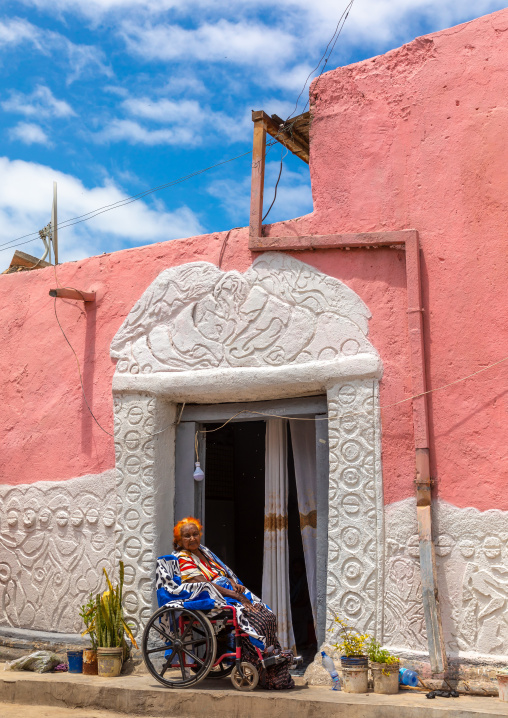 Disabled woman in front of a traditional house in the old town, Harari region, Harar, Ethiopia