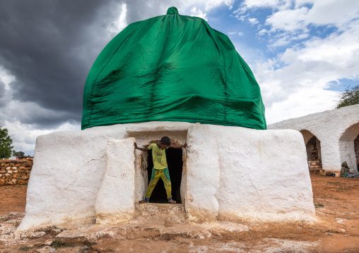 Oromo pilgrim boy in front of a shrine with green dome, Oromia, Sheik Hussein, Ethiopia