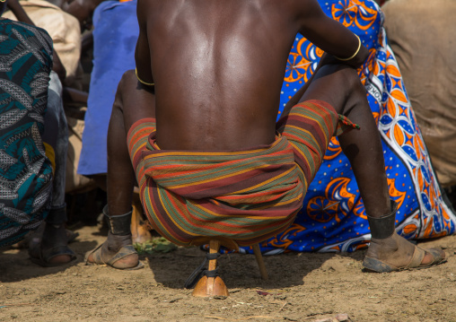 Warrior sit on his wooden seat during the proud ox ceremony in Dassanech tribe, Turkana County, Omorate, Ethiopia