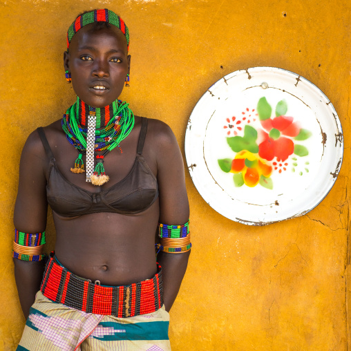 Hamer tribe woman standing at the entrance of a restaurant, Omo valley, Dimeka, Ethiopia