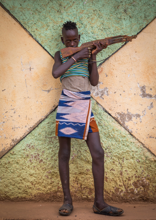 Hamer tribe boy with a wooden kalshnikov, Omo valley, Dimeka, Ethiopia
