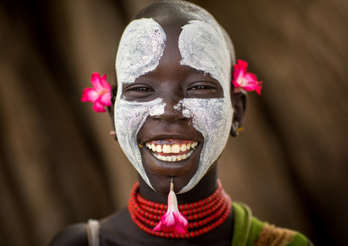 Portrait of a smiling Karo tribe child with flowers decorations, Omo valley, Korcho, Ethiopia