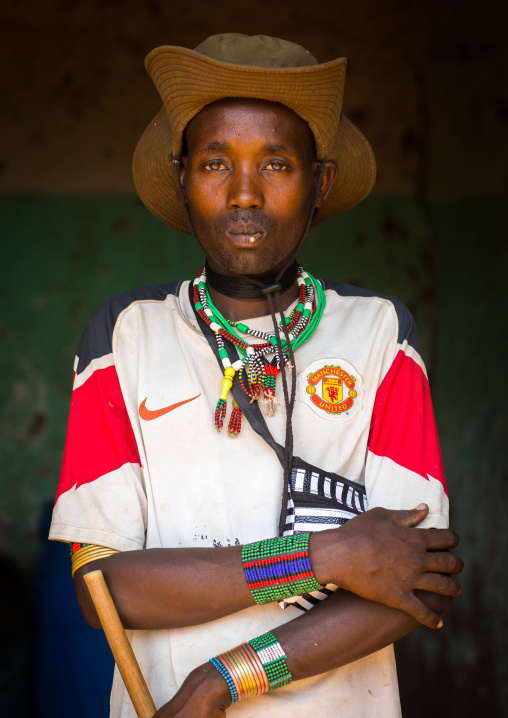 Portrait of a Hamer tribe man wearing a manchester united football shirt, Omo valley, Turmi, Ethiopia