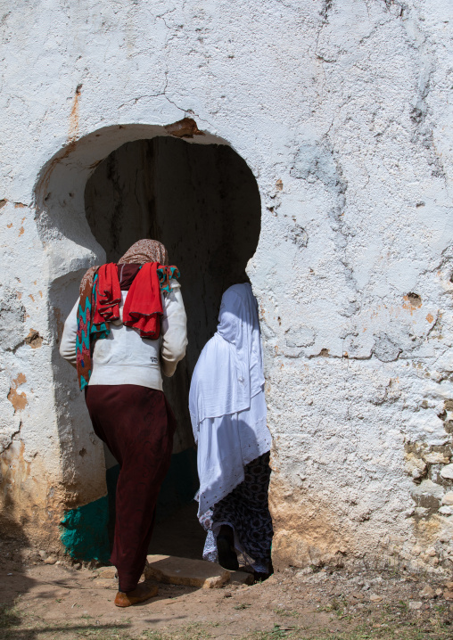 Harari women entering a door in a muslim holy site, Harari Region, Harar, Ethiopia