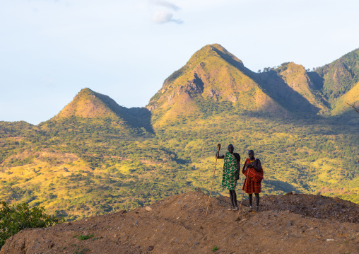 Suri tribe couple in front of a mountain landscape, Omo valley, Kibish, Ethiopia