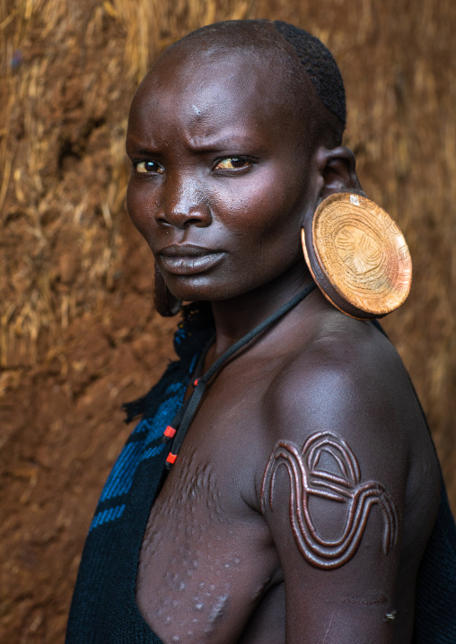 Portrait of a suri tribe woman with enlarged earlobes and huge earrings, Omo valley, Kibish, Ethiopia