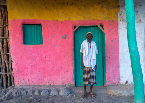 Portrait of an old afar tribe man in front of a pink house, Afar Region, Afambo, Ethiopia
