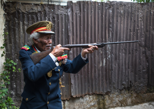 Ethiopian veteran from the italo-ethiopian war in army uniform pretending to shoot, Addis Ababa Region, Addis Ababa, Ethiopia