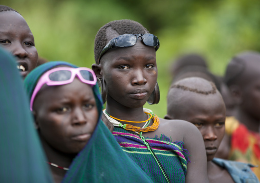 Suri tribe girls wearing sunglasses, Kibish, Omo valley, Ethiopia