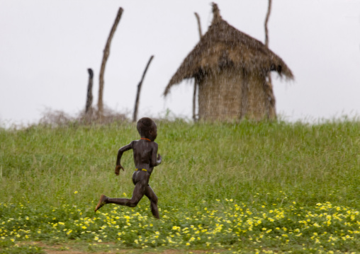 Kid From Karo Tribe Running Under The Rain, Korcho Village, Omo Valley, Ethiopia