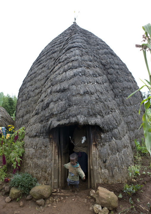 Kid at the door of a dorze tribe house made of wood poles and woven bamboo, Chencha, Ethiopia