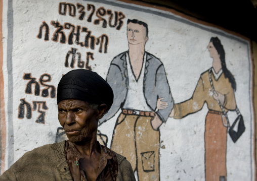 Couple painted on a wall with a senior black woman standing near, Addis ababa, Ethiopia