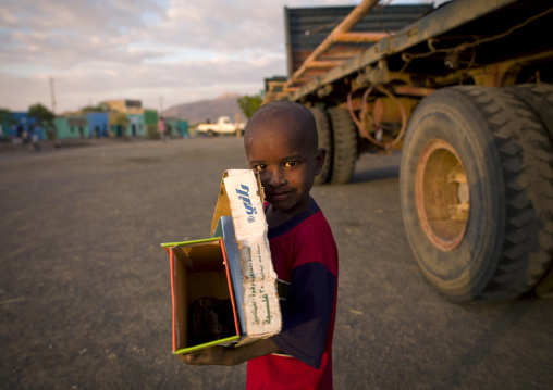 Boy collecting boxes in the street, Assaita, Ethiopia