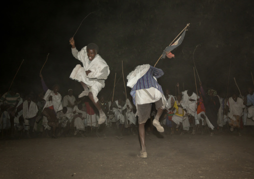 Night Shot Of Two Karrayyu Tribe Men Jumping High During A Choreographed Stick Fighting Dance At Gadaaa Ceremony, Metahara, Ethiopia