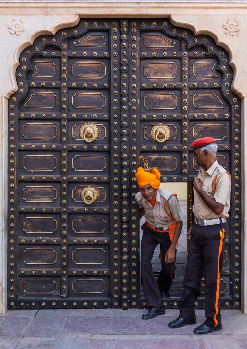 Indian guards in front of an old door in the city palace, Rajasthan, Jaipur, India