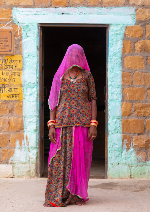Portrait of a rajasthani woman hidding her face under a pink sari, Rajasthan, Jaisalmer, India