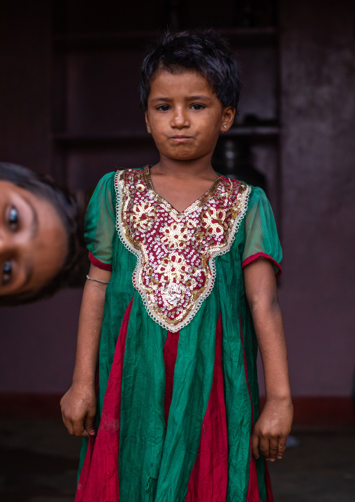 Indian girl in traditional clothing with a boy looking in the frame, Rajasthan, Jaisalmer, India