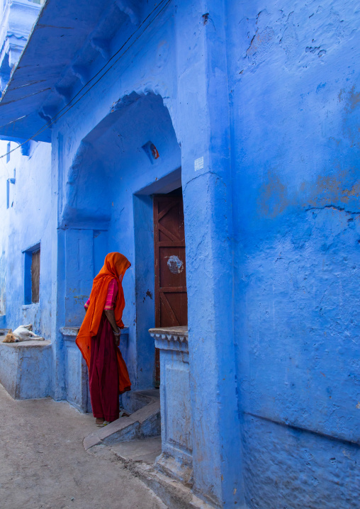 Indian woman entering an old blue house of a brahmin, Rajasthan, Bundi, India