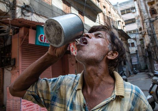 Indian man drinking in the street, Rajasthan, Jaipur, India