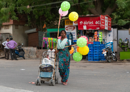 Indian woman with a stroller selling balloons in the street, Rajasthan, Bikaner, India