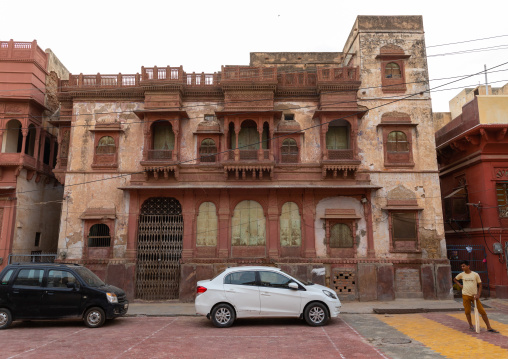 Indian young man playing cricket in front of a haveli in the old city, Rajasthan, Bikaner, India