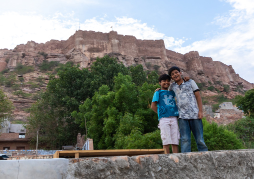 Children on the rooftop of their house in front of the fort, Rajasthan, Jodhpur, India