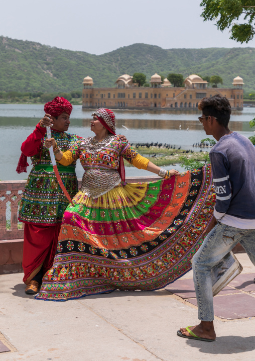Indian tourists posing in traditional clothing in front of jal mahal, Rajasthan, Jaipur, India