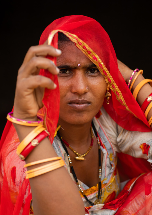 Portrait of a rajasthani woman in traditional red sari, Rajasthan, Jaisalmer, India