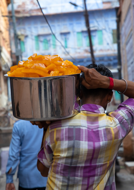 Indian man carrying food in the street, Rajasthan, Jodhpur, India