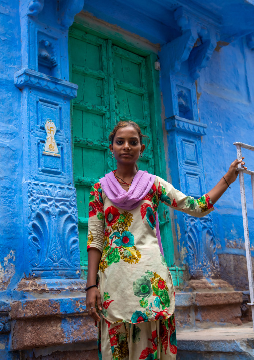 Portrait of a rajasthani teenage girl in traditional sari in front of a blue house, Rajasthan, Jodhpur, India