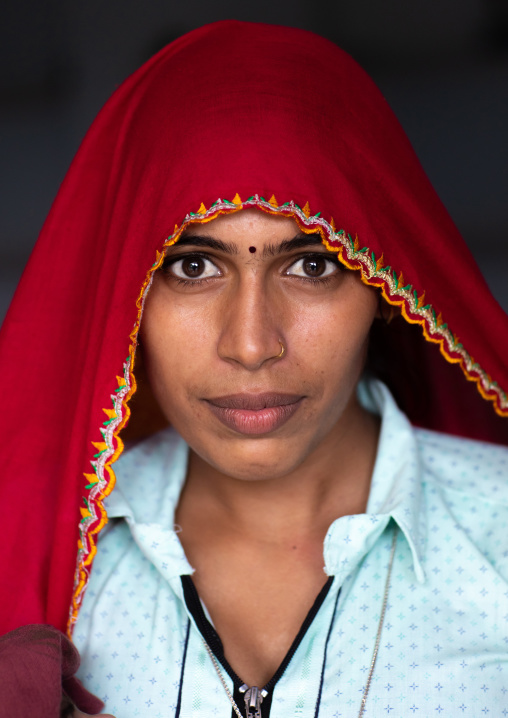 Portrait of a rajasthani woman in traditional red sari, Rajasthan, Baswa, India