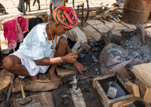 Indian blacksmith forging metal at work, Rajasthan, Jaisalmer, India
