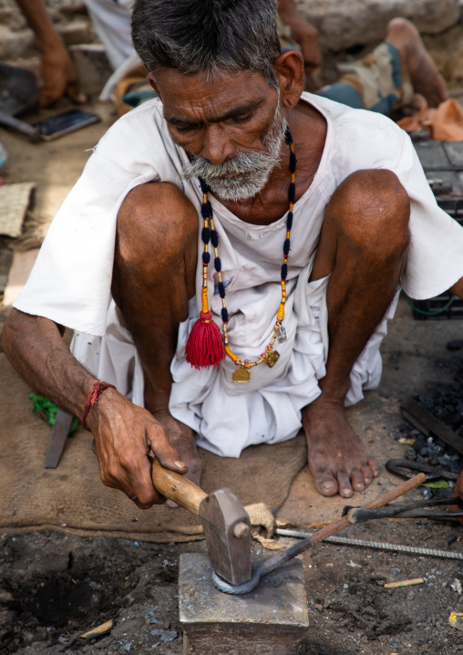 Indian blacksmith forging metal at work, Rajasthan, Jaisalmer, India
