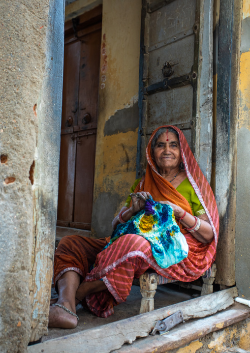 Portrait of a rajasthani woman in traditional sari sewing, Rajasthan, Nawalgarh, India