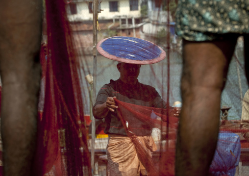 Mahe Fisherman With Traditional Hat Emptying His Nets, India