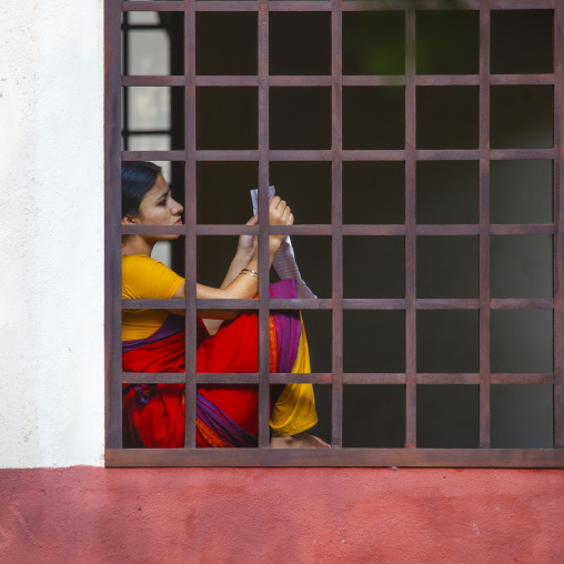 Young Woman Holding A Sheet Of Paper Sitting On The Edge Of A Bar Window At Dakshinachitra Dance Center, Chennai, India