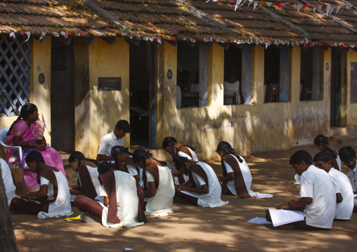 Group Of Students In Uniform Studying Sitting On The Ground In Front Of The Classroom, Mahabalipuram, India