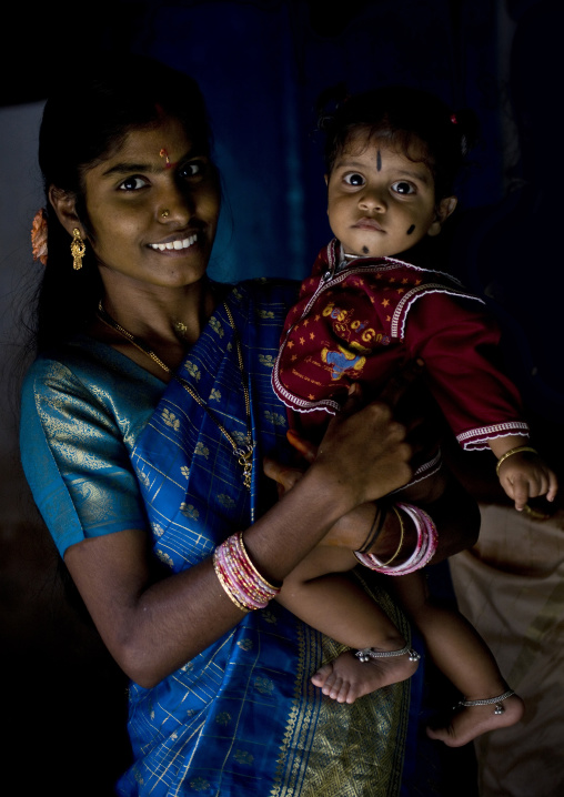Young Smiling Mother With Traditional Clothes And Painting On Her Forehead  Holding Her Baby Girl In Her Arms, Kumbakonam, India